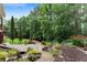 Beautifully landscaped backyard with a stone patio, lush garden, and mature trees for privacy and outdoor enjoyment at 32 Pullman Trl, Acworth, GA 30101