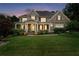 Beautiful home at dusk featuring a manicured lawn and welcoming covered front porch at 32 Pullman Trl, Acworth, GA 30101