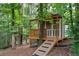 Charming outbuilding nestled among mature trees, featuring a ramp, deck, and screened doors at 32 Pullman Trl, Acworth, GA 30101