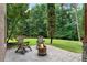 Cozy backyard patio with a stone fire pit and two wooden chairs surrounded by lush greenery providing a private outdoor space at 32 Pullman Trl, Acworth, GA 30101