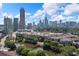 Expansive aerial view showcasing the property amidst a vibrant cityscape, lush trees, and a tranquil pond at 390 17Th Nw St # 2005, Atlanta, GA 30363