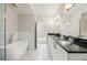 A modern bathroom featuring a freestanding tub, double sinks, and granite countertops at 390 17Th Nw St # 2005, Atlanta, GA 30363