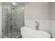 A stylish bathroom with a glass-enclosed shower, a soaking tub, and tiled walls at 390 17Th Nw St # 2005, Atlanta, GA 30363
