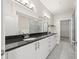 A well-lit bathroom featuring double sinks, granite countertops, and a shower at 390 17Th Nw St # 2005, Atlanta, GA 30363