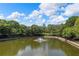 Scenic pond featuring a fountain, blue skies, and landscaped greenery at 390 17Th Nw St # 2005, Atlanta, GA 30363