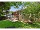 Large backyard with a wooden deck and patio, surrounded by lush trees at 1117 Haven Glen Ne Ln, Brookhaven, GA 30319