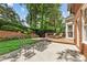 Private backyard with a wooden deck, concrete patio, lush landscaping and mature trees at 1117 Haven Glen Ne Ln, Brookhaven, GA 30319