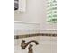 Close up shot of the soaking tub with bronze fixtures and neutral stone tile at 1117 Haven Glen Ne Ln, Brookhaven, GA 30319