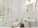 Bathroom with a toilet, a white sink and a window with white shutters at 1117 Haven Glen Ne Ln, Brookhaven, GA 30319
