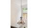 Hallway featuring an ornate chandelier with candle-style lights and view to an exterior window at 1117 Haven Glen Ne Ln, Brookhaven, GA 30319