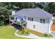 Aerial view of backyard featuring a deck with blue umbrella, mature trees, lush lawn, and privacy at 2355 Quail Creek Ter, Buford, GA 30519