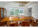 Well-lit dining room with a long wooden table, seating for eight, and beautiful views of the greenery outside at 2355 Quail Creek Ter, Buford, GA 30519