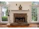 Classic fireplace with stone hearth and white mantel flanked by large windows at 2355 Quail Creek Ter, Buford, GA 30519