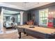 Spacious game room featuring a pool table, hardwood floors, dark grey walls and classic car parked in the adjacent garage at 2355 Quail Creek Ter, Buford, GA 30519