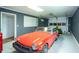 Garage featuring a red classic convertible, a green lawn mower and a peg board for tool and equipment storage at 2355 Quail Creek Ter, Buford, GA 30519