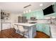 Eat-in kitchen features light-blue cabinets, stainless steel appliances, and a marble-top center island with seating at 2355 Quail Creek Ter, Buford, GA 30519