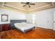Spacious main bedroom featuring hardwood floors, tray ceilings, and a large comfortable bed at 2355 Quail Creek Ter, Buford, GA 30519