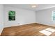 Bright bedroom with hardwood floors, white walls, and natural light from two windows at 2585 Regency E Dr, Tucker, GA 30084