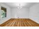 Elegant dining room with hardwood floors, modern chandelier, and large window with natural light at 2585 Regency E Dr, Tucker, GA 30084