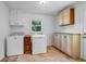 Functional laundry room with white appliances, storage cabinets, and tile flooring at 2585 Regency E Dr, Tucker, GA 30084
