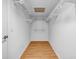 Walk-in closet with hardwood floors and white shelves for storage and organization at 2585 Regency E Dr, Tucker, GA 30084