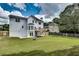 Wide shot of house backyard with a fire pit, green lawn and perimeter fencing and mature trees at 1226 Kelly Nelson Ct, Lawrenceville, GA 30043