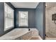 Bathroom featuring a shower with marble-style tile and a soaking tub with windows at 1226 Kelly Nelson Ct, Lawrenceville, GA 30043