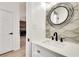 Modern half-bath with circular mirror and a decorative stone wall at 1226 Kelly Nelson Ct, Lawrenceville, GA 30043