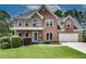 Charming brick home with two-car garage, manicured lawn, and inviting covered front porch at 1226 Kelly Nelson Ct, Lawrenceville, GA 30043