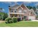 Two-story brick home featuring an attached two car garage, gabled roof and manicured lawn at 1226 Kelly Nelson Ct, Lawrenceville, GA 30043
