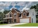 Two-story brick home featuring an attached two car garage, gabled roof and manicured lawn at 1226 Kelly Nelson Ct, Lawrenceville, GA 30043