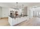 An open kitchen has a gray countertop island, stainless appliances, and decorative backsplash at 1226 Kelly Nelson Ct, Lawrenceville, GA 30043