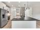 A modern white kitchen boasts stainless steel appliances and a gray countertop island with decorative lighting at 1226 Kelly Nelson Ct, Lawrenceville, GA 30043