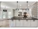 Bright kitchen featuring a gray countertop island with pendant lights, white cabinetry, and modern stainless appliances at 1226 Kelly Nelson Ct, Lawrenceville, GA 30043