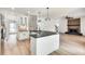 Open layout showcasing kitchen with stainless appliances, connecting to the living area with a fireplace at 1226 Kelly Nelson Ct, Lawrenceville, GA 30043