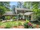 Back exterior view of two-story brick home with screened porch and lush landscaping at 1691 Houghton N Ct, Atlanta, GA 30338