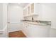 Stylish bar area featuring white cabinetry, granite countertop, and hardwood floors for entertaining at 1691 Houghton N Ct, Atlanta, GA 30338