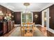 Formal dining room with dark walls, elegant chandelier, and a view into a bright kitchen space at 1691 Houghton N Ct, Atlanta, GA 30338