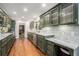 Galley kitchen featuring unique dark green cabinets, granite countertops, and hardwood floors at 1691 Houghton N Ct, Atlanta, GA 30338