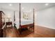 Bright main bedroom with hardwood floors, four-poster bed, and ensuite bathroom access at 1691 Houghton N Ct, Atlanta, GA 30338