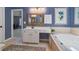 Bathroom features a soaking tub, tile flooring, a large mirror, and a white vanity at 3401 Village Green Dr, Roswell, GA 30075