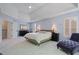 This bedroom is spacious and features a ceiling fan, a chaise lounge, and neutral carpeting at 3401 Village Green Dr, Roswell, GA 30075