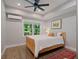 Comfortable bedroom featuring wood flooring, a ceiling fan, and bright natural light at 3401 Village Green Dr, Roswell, GA 30075
