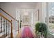 Bright entryway features hardwood floors, elegant staircase, and wainscoting, leading to a glass-paneled front door at 3401 Village Green Dr, Roswell, GA 30075