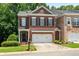 Charming red brick townhome with manicured lawn, attached two car garage, and classic architectural details at 3401 Village Green Dr, Roswell, GA 30075