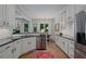 Modern kitchen with stainless steel appliances, white cabinetry, dark countertops, and hardwood flooring at 3401 Village Green Dr, Roswell, GA 30075