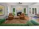 Cozy living room with fireplace, hardwood floors, shuttered windows, and comfortable seating with natural light at 3401 Village Green Dr, Roswell, GA 30075