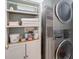 A modern laundry room with stacked washer and dryer units, and built-in shelving at 508 Keeneland Ave, Woodstock, GA 30189