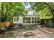 Cozy backyard featuring a screened porch, a fire pit, and a swing, all surrounded by lush trees and a wooden fence at 348 7Th Ne St, Atlanta, GA 30308