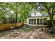 Cozy backyard featuring a screened porch, a fire pit, and a swing, all surrounded by lush trees and a wooden fence at 348 7Th Ne St, Atlanta, GA 30308